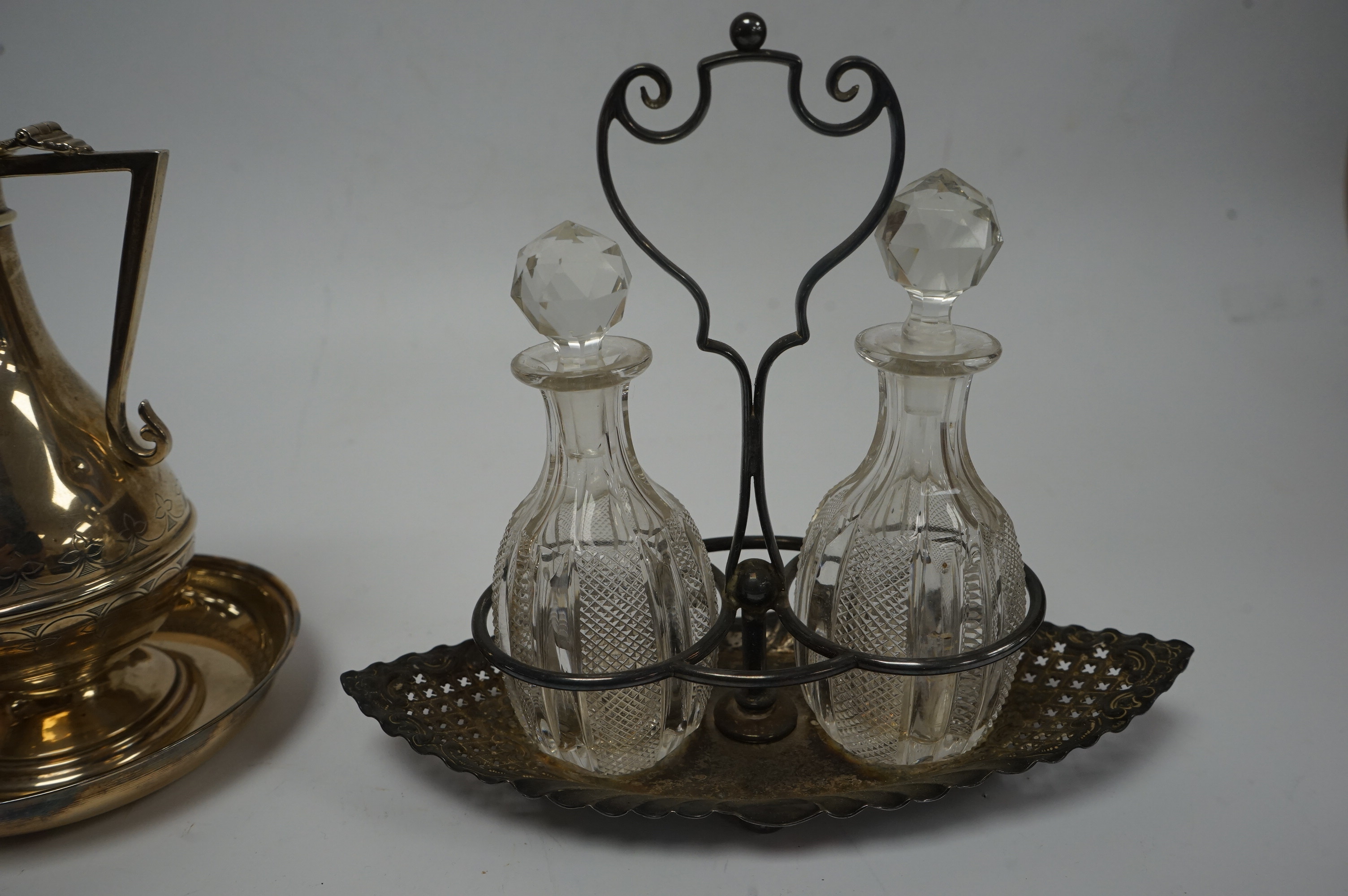 An Edwardian silver communion jug, by James Deakin & Sons, London, 1908, 15.2cm, together with a late Victorian repousse silver cruet stand with two glass bottles and stoppers, James Dixon & Sons, Sheffield, 1897 and a c